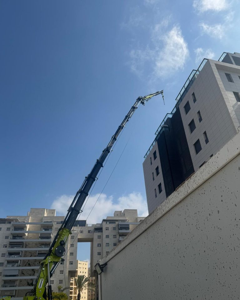 מנוף טלסקופי פרוס לגובה לצד בניין מגורים