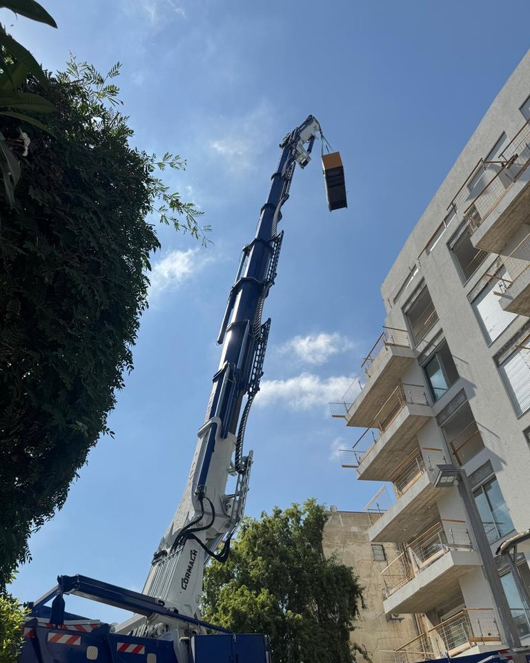 מנוף נייד מרים מטען אל בניין מגורים